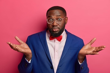 Clueless shocked businessman has hesitation, expresses uncertainty, puzzled what do better, wears optical glasses, formal suit, red bowtie